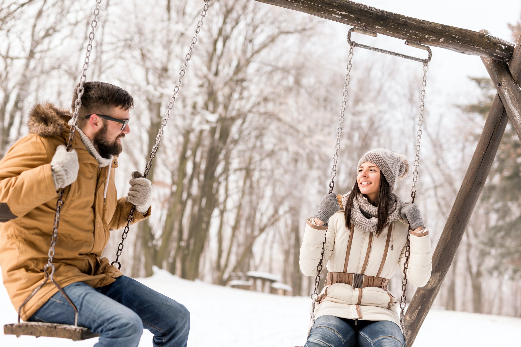 Couple sitting on swings