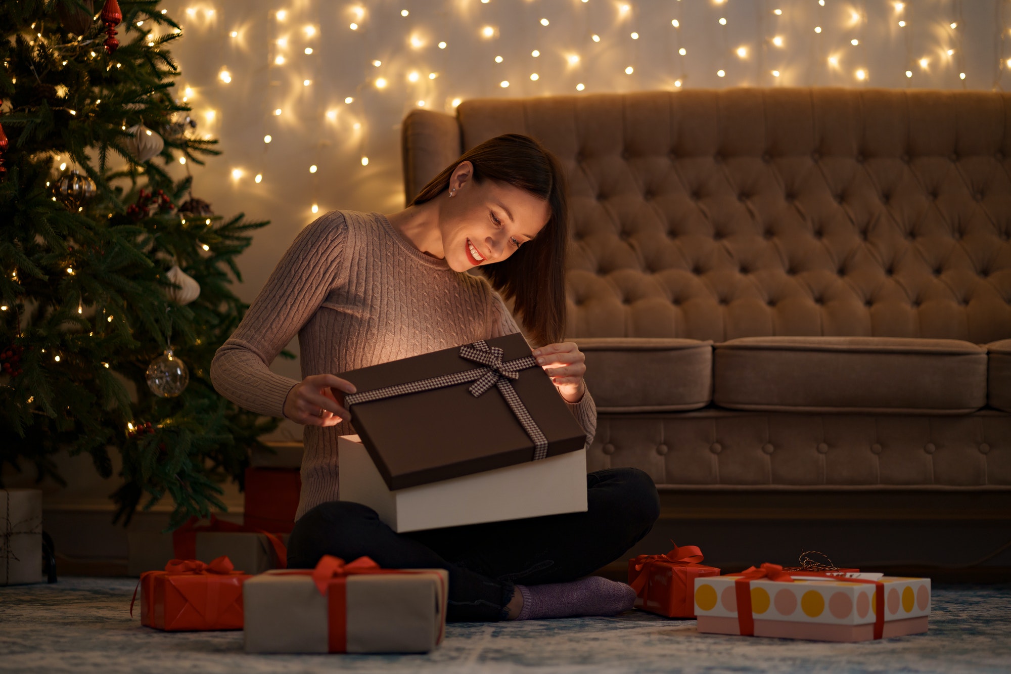 Happy beautiful woman opening a gift